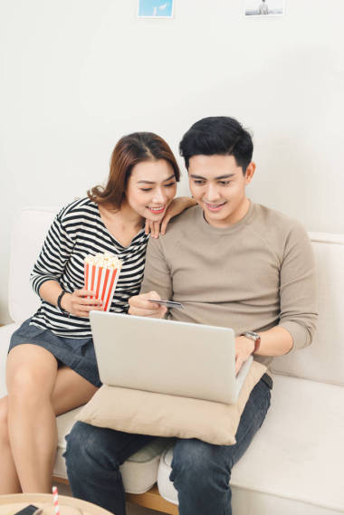 看在他們的客廳里電視輕松年輕夫婦