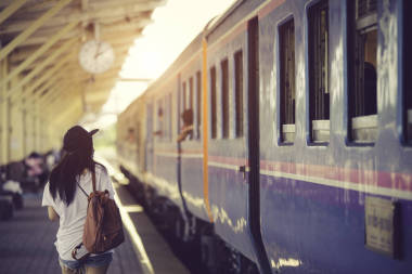 旅行者女人走，等待火車鐵路平臺上