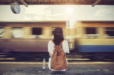旅行者女人走，等待火車(chē)鐵路平臺(tái)上