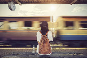 旅行者女人走，等待火车铁路平台上