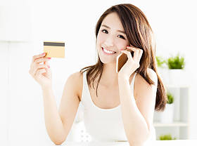 女人买在线信用卡与智能手机图片