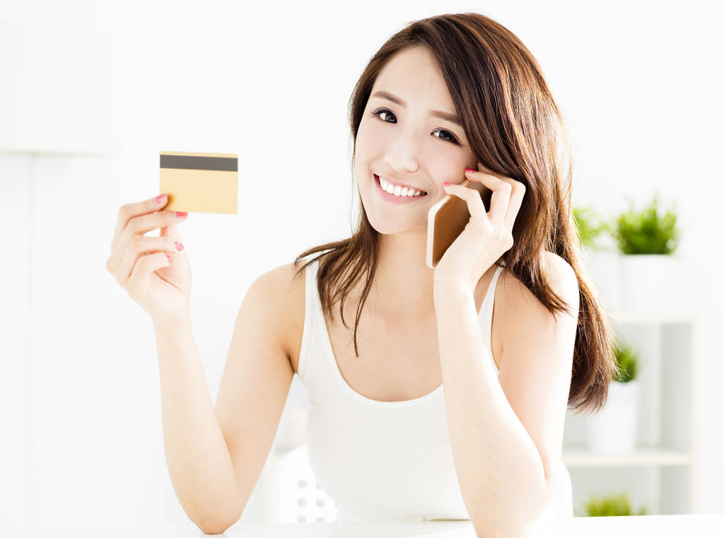 女人买在线信用卡与智能手机图片