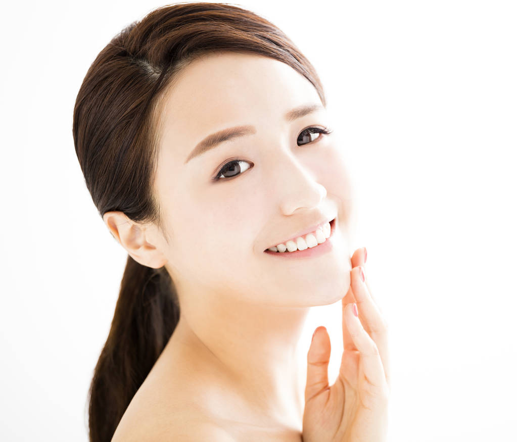 特写镜头与清洁面部美丽的年轻女子
