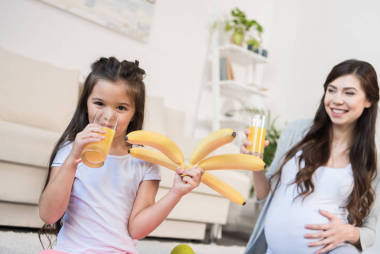 女孩拿着香蕉和喝果汁图片