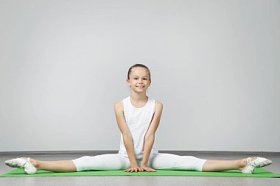 年轻姑娘做绿色瑜伽垫上练习