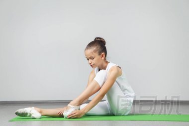 年輕姑娘做綠色瑜伽墊上練習