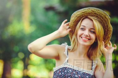 美麗微笑的年輕女子在帽子、 喜悅和有趣，輕松和舒適的溫暖照片處理