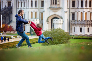 父親，他的小兒子在前面的草坪上轉著圓圈