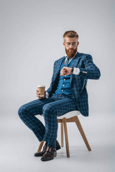 時(shí)尚的男人，檢查在手表上的時(shí)間