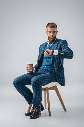 时尚的男人，检查在手表上的时间