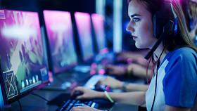 职业女孩在Mmorpg玩家戏剧/战略电子游戏在她的电脑上。她参加网络游戏比赛，在家或网吧玩游戏。她戴着游戏耳机
