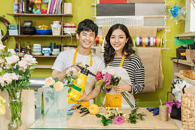 男性和女性的花店，与美丽的鲜花，在花店