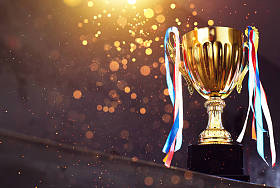 低调的金色奖杯在模糊的灰色背景与抽象闪亮的灯光 