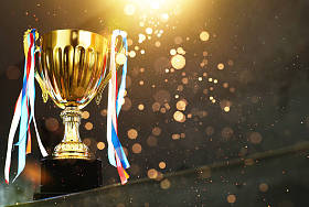 低调的金色奖杯在模糊的灰色背景与抽象闪亮的灯光 