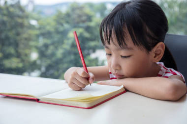 亞洲中國(guó)小女孩寫的家庭作業(yè)圖片