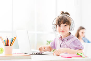 可爱的小女孩带着便携式计算机连接