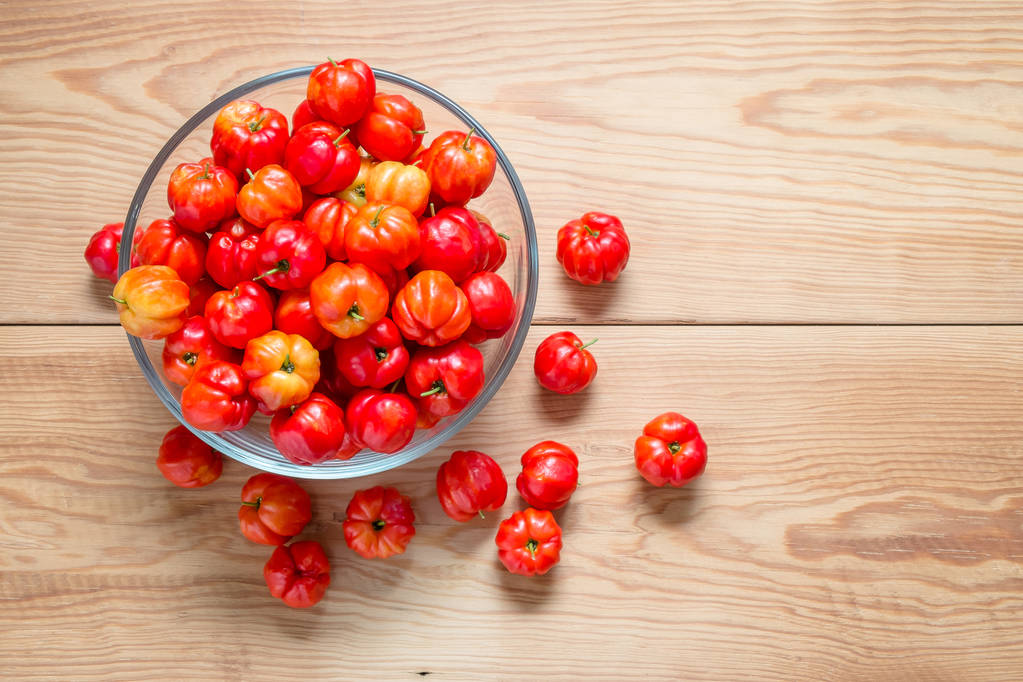 新鲜的樱桃木桌上的玻璃碗里照片 新鲜的樱桃木桌上的玻璃碗里照片
