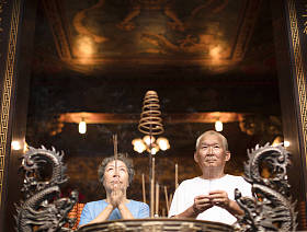 焚香祈祷佛的年长夫妇坚持在寺
