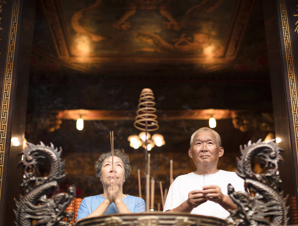 焚香祈祷佛的年长夫妇坚持在寺
