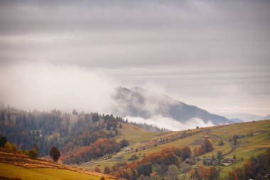 山與彩林的秋景。在村莊嗨照片