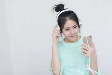 年輕的亞裔女子聽音樂與智能手機