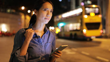 在手機(jī)上使用出租車(chē) app 的女人