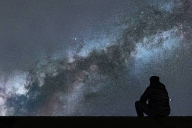 銀河系。夜晚的天空，星星與剪影單獨人看