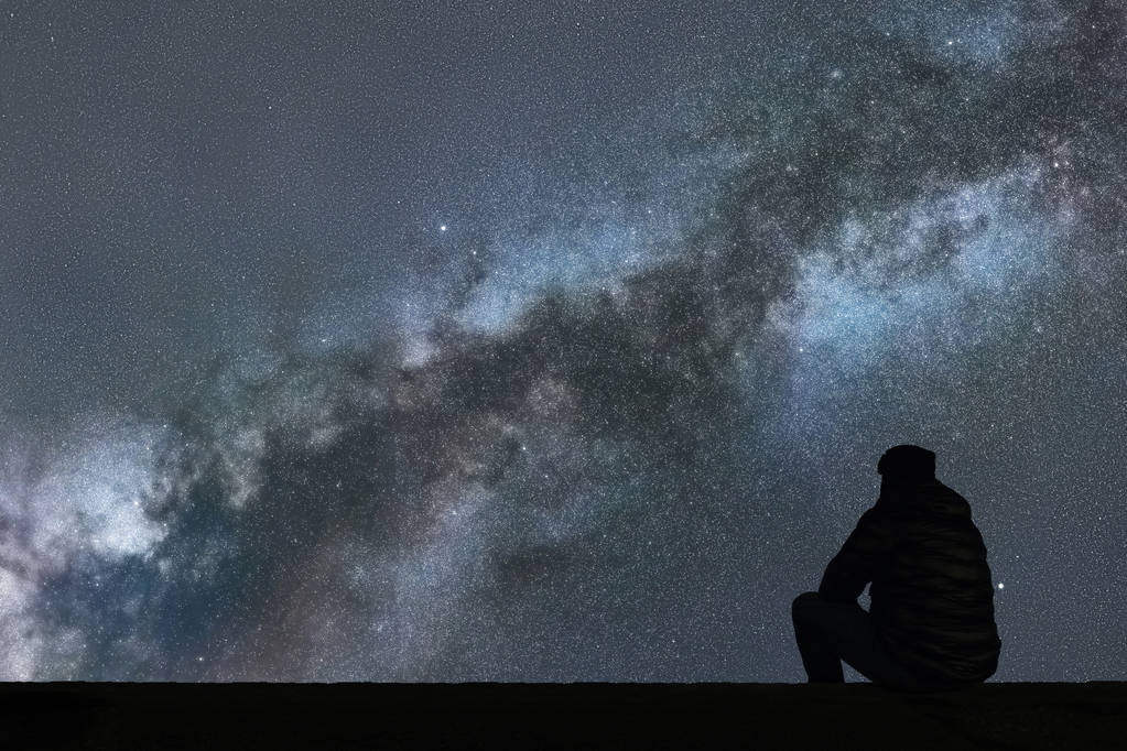 银河系。夜晚的天空,星星与剪影单独人看 银河系。夜晚的天空,星星与剪影单独人看