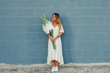 抱著花束的衣服的女人 