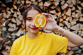 年轻的滑稽女孩，明亮的化妆，穿上黄色衬衫举行 