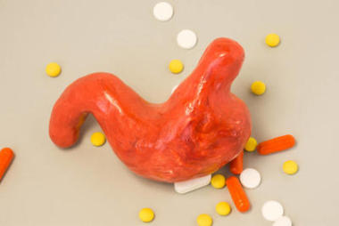 照片的藥物治療疾病的胃或胃、 其他消化系統(tǒng)的主意。模型的胃與十二指腸在灰色的背景下，藥品被包圍