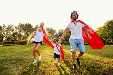 在日落公園的超級英雄的西裝幸福的家庭