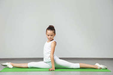 年輕姑娘做綠色瑜伽墊上練習(xí)圖片