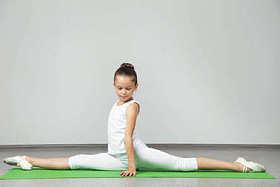 年轻姑娘做绿色瑜伽垫上练习图片