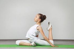 年轻姑娘做绿色瑜伽垫上练习