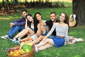 朋友放松在野餐会上，吉他图片