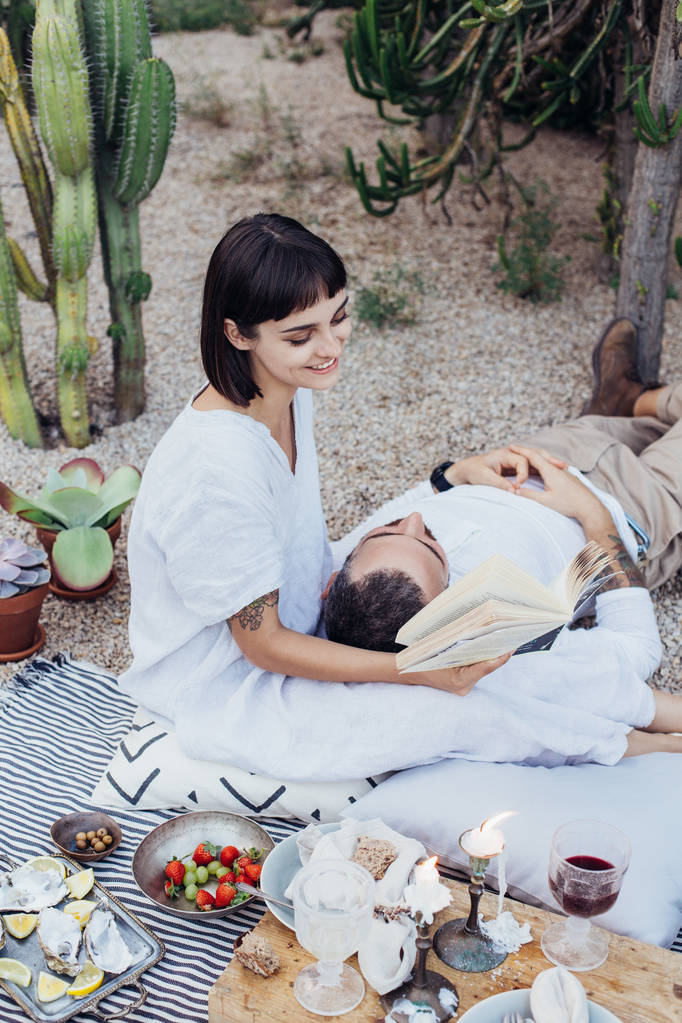 浪漫的约会的情侣躺在野餐毯子上