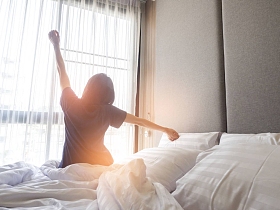 醒来后，后面的观点伸展躺在床上的女人