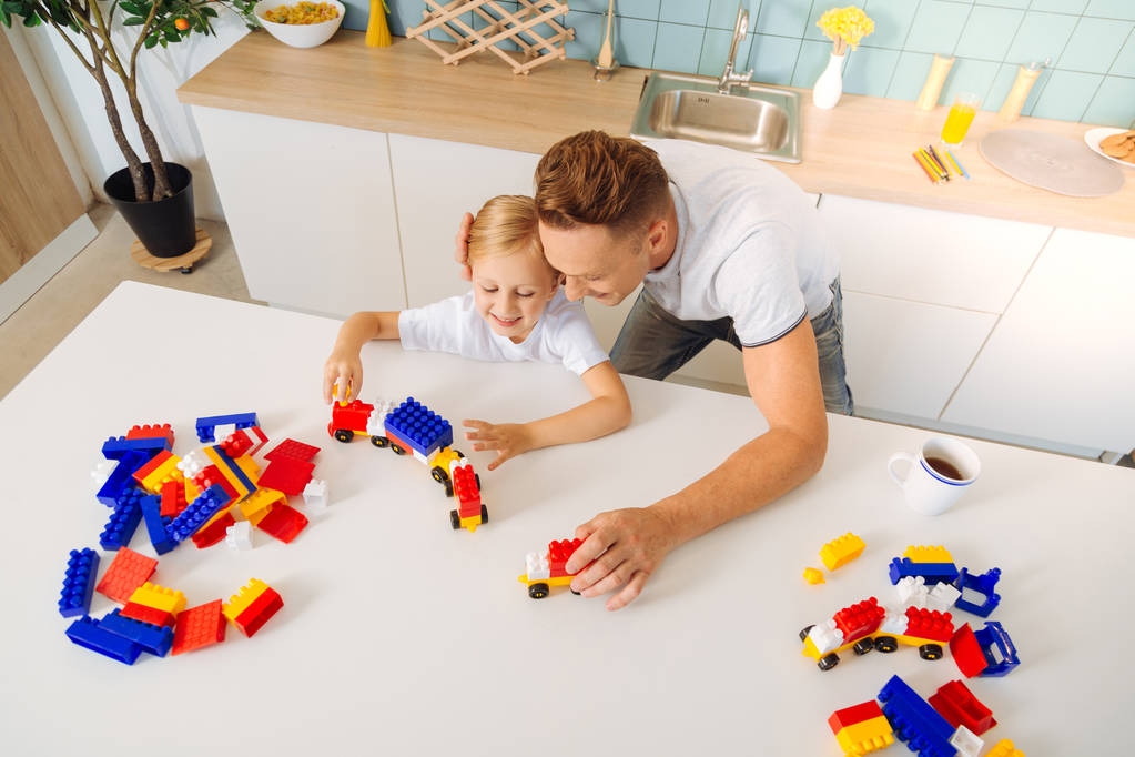 顶视图的一个快乐仁爱的父亲和他的女儿一起玩 顶视图的一个快乐仁爱的父亲和他的女儿一起玩