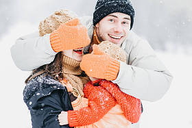 可爱的家庭在冬季公园里玩