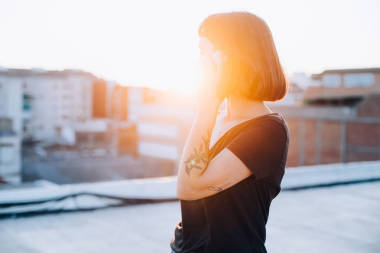 美麗的女人談智能手機在日落照片