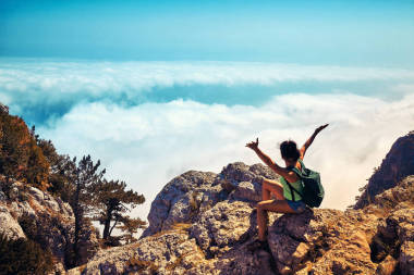 幸福的女人舉起手在日落山圖片