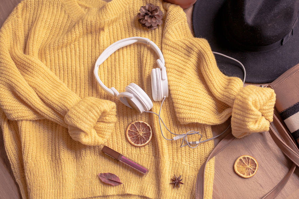 秋天。舒适。针织保暖的衣服。家居的舒适性。温暖的秋天。毛衣和帽子上木制的背景。冬天 秋天。舒适。针织保暖的衣服。家居的舒适性。温暖的秋天。毛衣和帽子上木制的背景。冬天