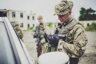 检查站的士兵拦住一辆车来检查证件