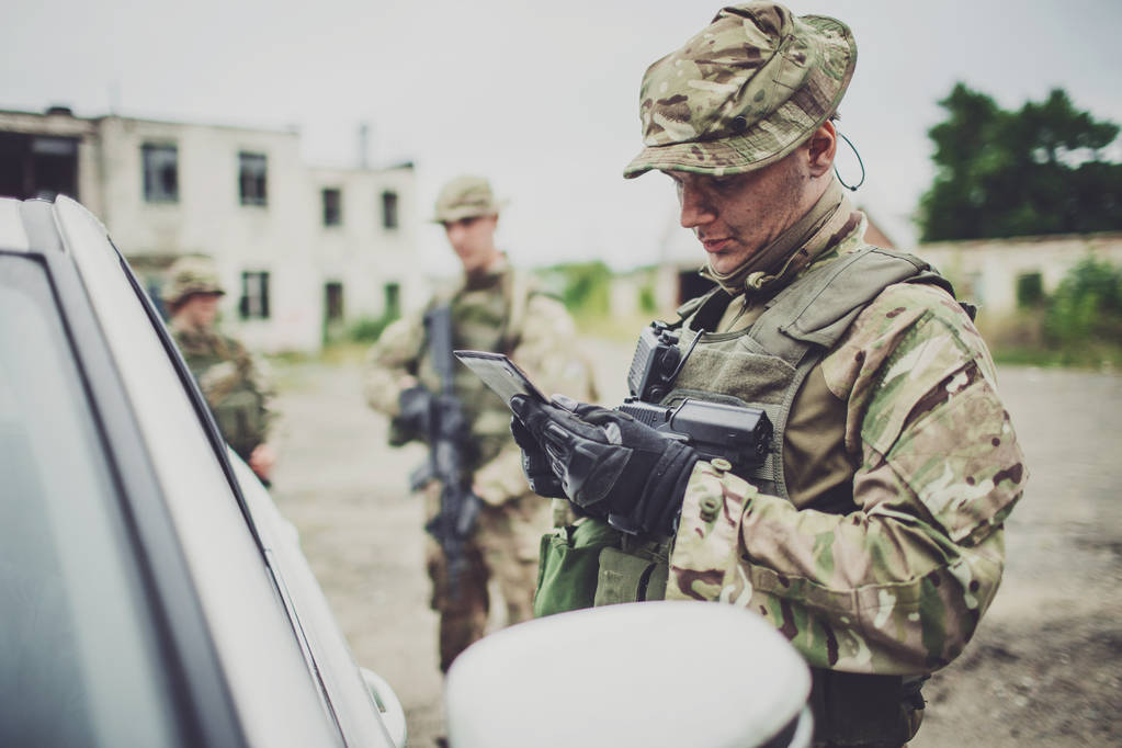 检查站的士兵拦住一辆车来检查证件 检查站的士兵拦住一辆车来检查证件