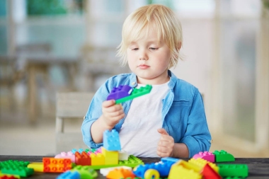 小男孩玩彩色塑料建筑积木图片