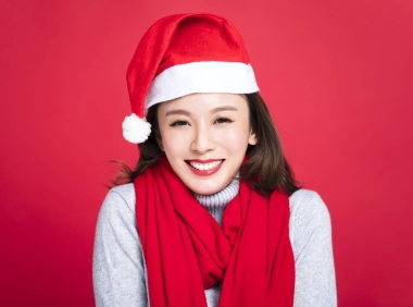 圣誕女郎穿著圣誕老人的帽子和微笑