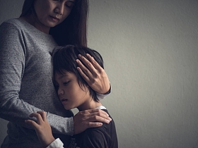 伤心的小男孩在家里被妈妈拥抱