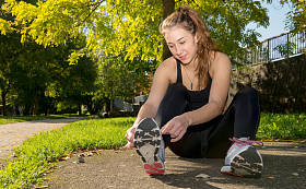 年轻女子赛跑者绑她准备慢跑的鞋子