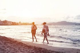 在沙滩上散步的妇女照片